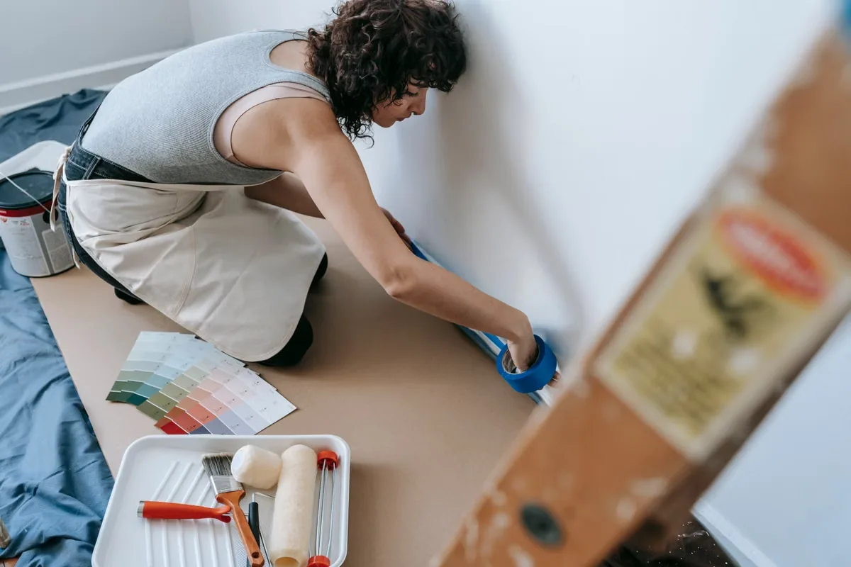 A person preparing a wall for redecorating