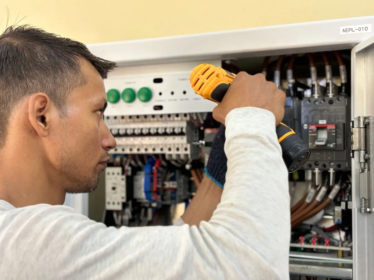 An electrician checking the electrical panel in a property