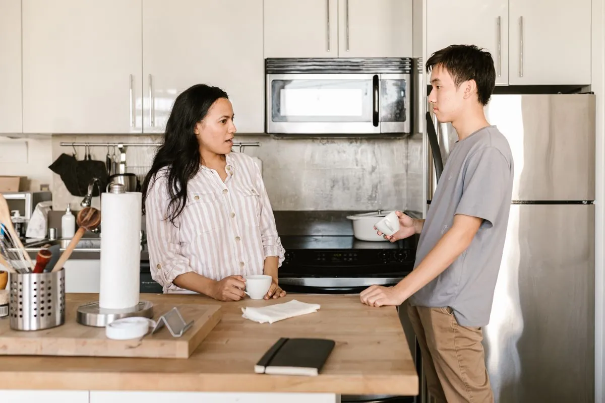 Housemates talking together in a shared kitchen
