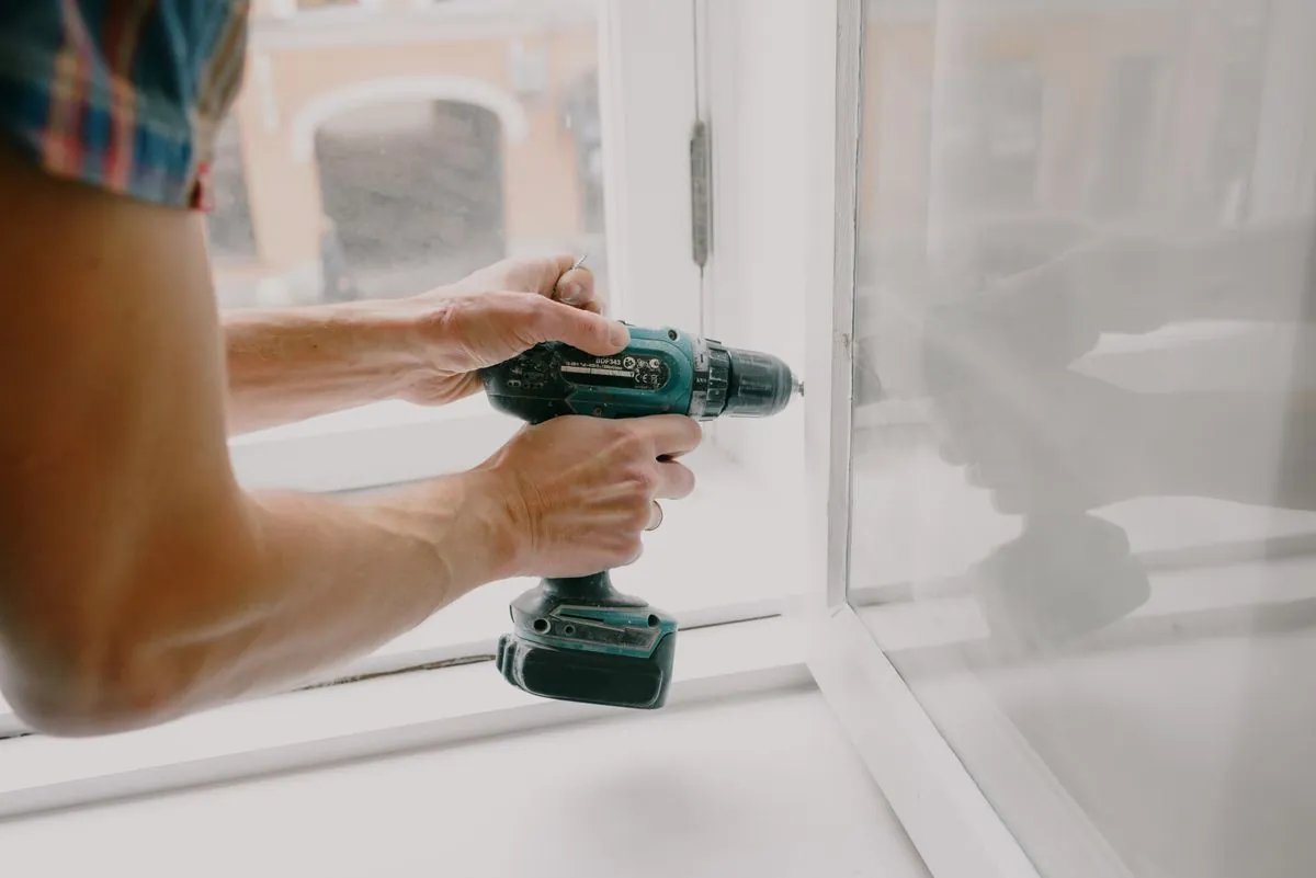 A tradesperson repairing a window frame