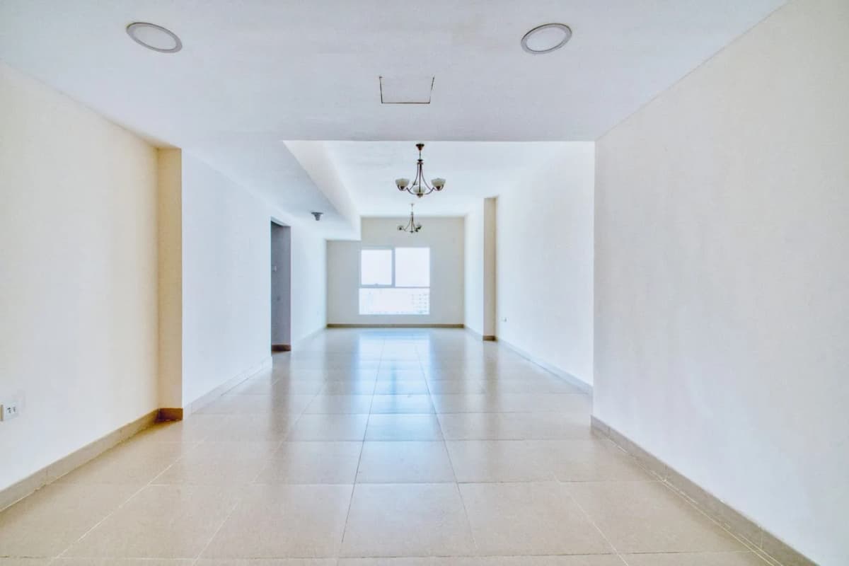 An unfurnished apartment with large windows, ready for preparation before occupation