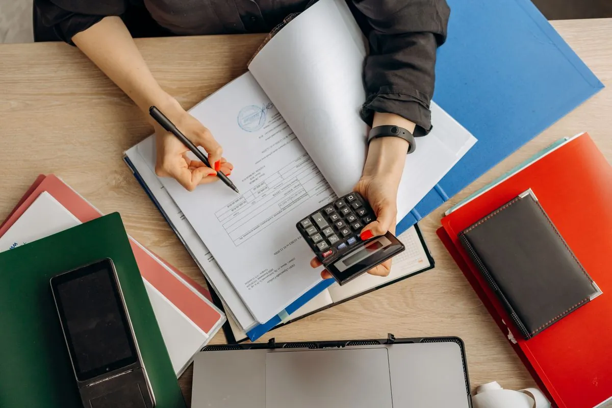 A professional organising documents and records at a desk