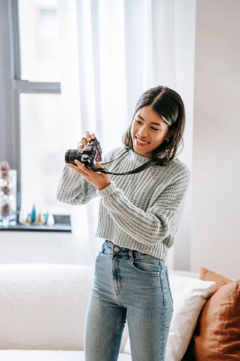 A woman using a camera in a bright home interior